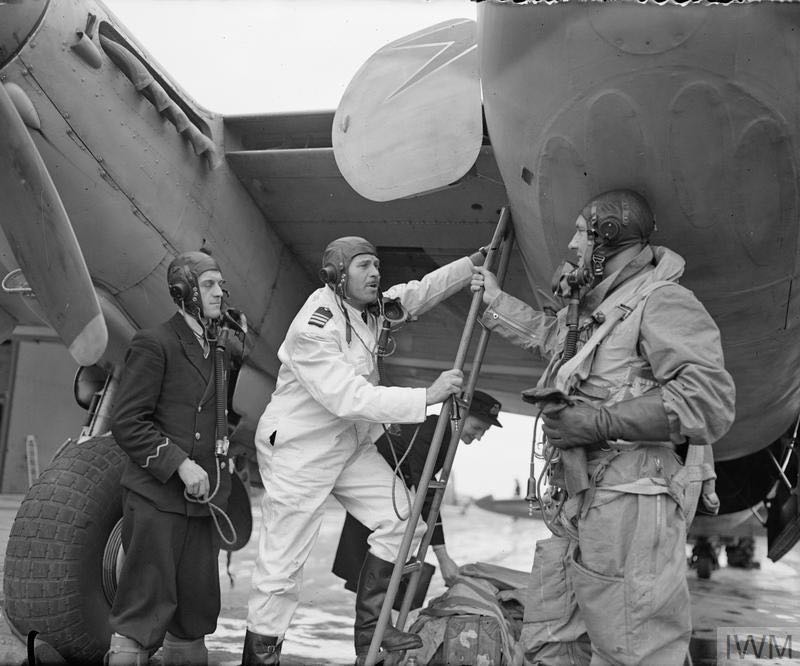 A passenger (right), who has been carried in the bomb-bay of a 'civilianised' De Havilland Mosquito FB Mark VI of BOAC on the fast freight service from Stockholm, Sweden, congratulates Captain Wilkins and his navigator on their safe arrival at at Leuchars, Fife. &copy; IWM (CH 20958)