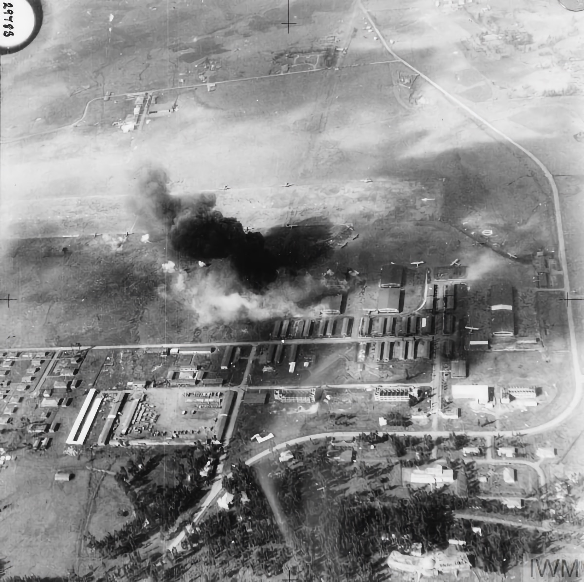 Bombs explode on buildings and Italian aircraft at Addis Ababa airfield. The photo is not from one of the attacks that Fg Off. Møller participated in, but gives an impression of how it must have looked from his Blenheim on those occasions (IWM &copy; CM 69)