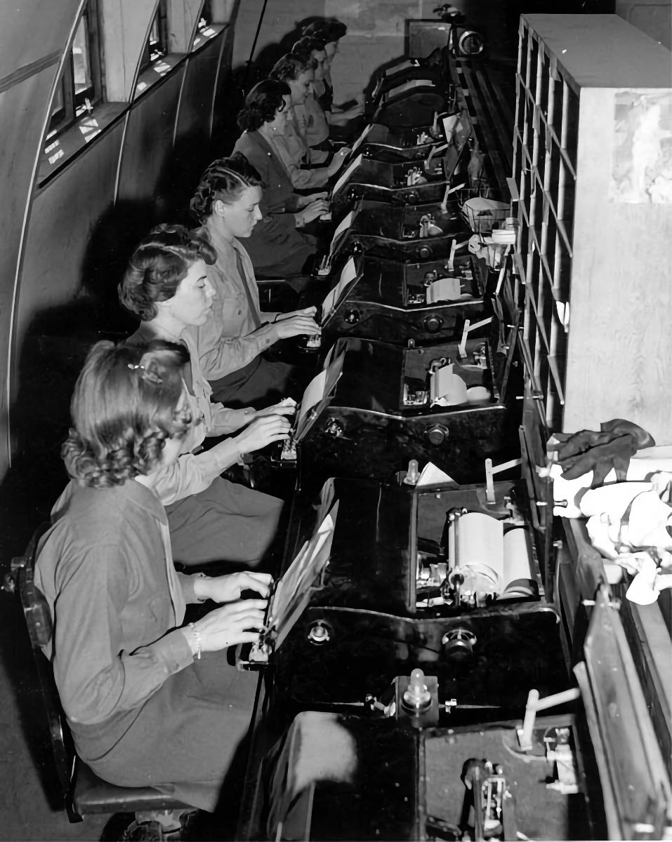 Women's Army Corp (WAC) personnel typing teletype messages at a communications center. O’Brien may have worked in a similar environment during her overseas service.