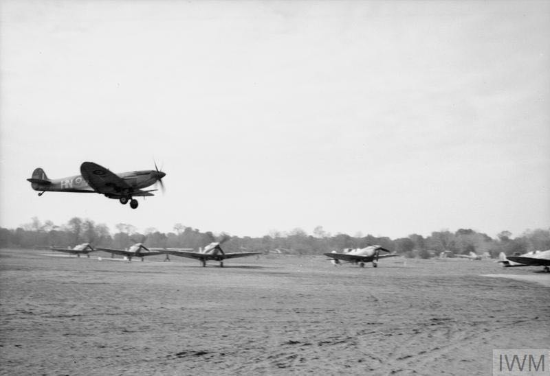 A Spitfire IX of 93 Squadron comes in to land at Lago landing ground, near Castel Volturno, after a patrol over the Anzio beach-head, while other Spitfires of 324 Wing RAF line up by the runway, ready to take off (&copy; IWM CNA 2434).