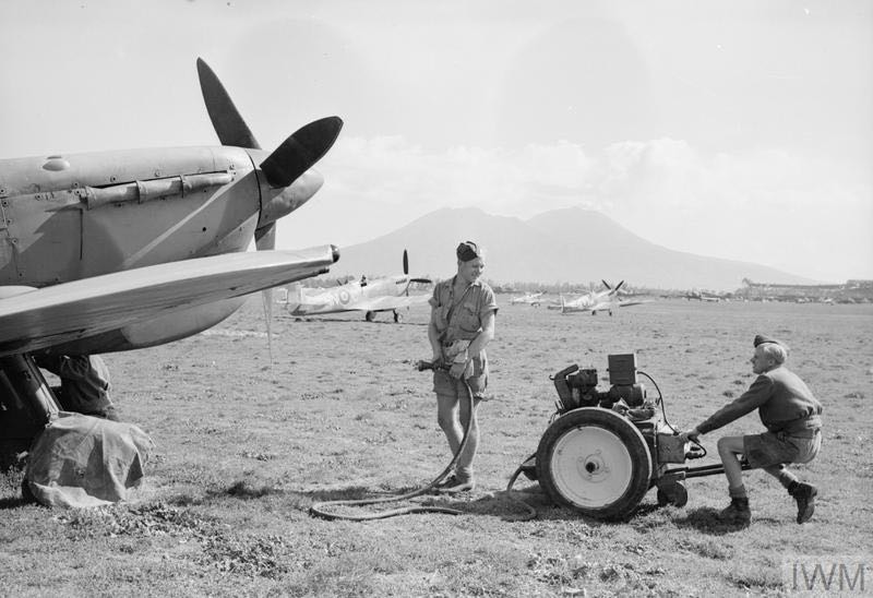 Ground crew prepare to start a Spitfire Mark VC of 324 Wing at Capodichino near Naples, using a trolley-accumulator. Spitfire IXs of 93 Squadron—possibly MH934 ‘HN-C’ and MA728 ‘HN-D’—can be seen parked in the background, with Mount Vesuvius in the distance. Tambour flew MA728 on several occasions (© IWM CNA 4663).