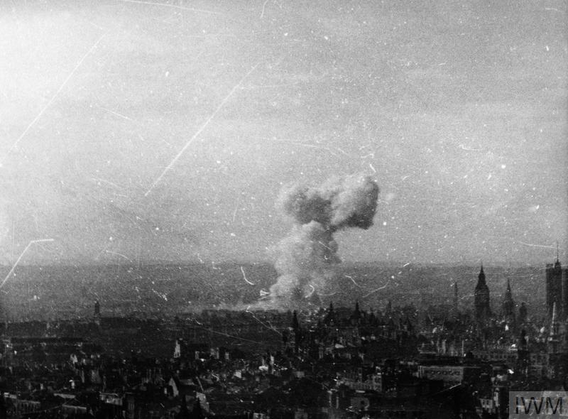 A view over the rooftops of London captured on cine film as a V1 flying bomb explodes close to Westminster in London. Big Ben and the Houses of Parliament can be seen on the right. © IWM ([MOI] FLM 2000)