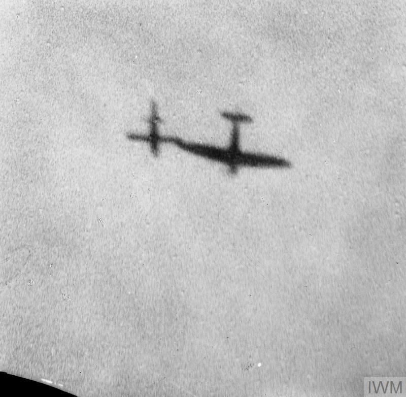 Seen in silhouette, a Supermarine Spitfire manoeuvres alongside a flying bomb in an attempt to deflect it from its target. © IWM (CH 16281)
