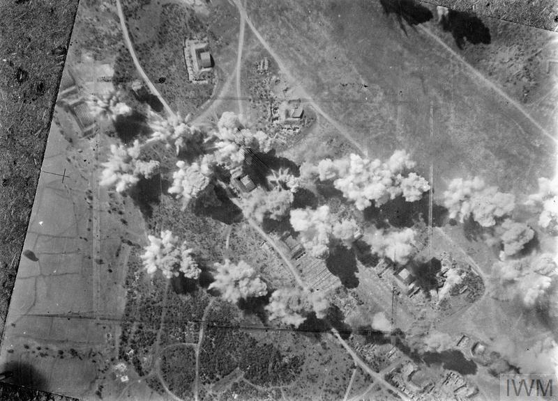 Sticks of bombs explode on and around hangars, dispersal points and administrative buildings during a daylight attack on the airfield at Kangaung, Burma, by Liberators of No. 231 Group. It is possible that the attack in question is the attack on 18 January 1945 in which Bruun took part. (© IWM C 4950)